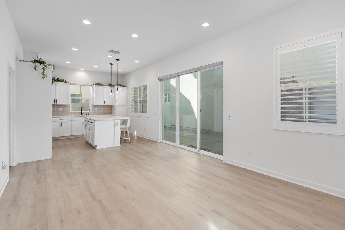 Your Main Living Space taken from near the Garage access door. Glass sliding door to your Private Patio on the right. Door to your Main Floor Primary Suite on the left.